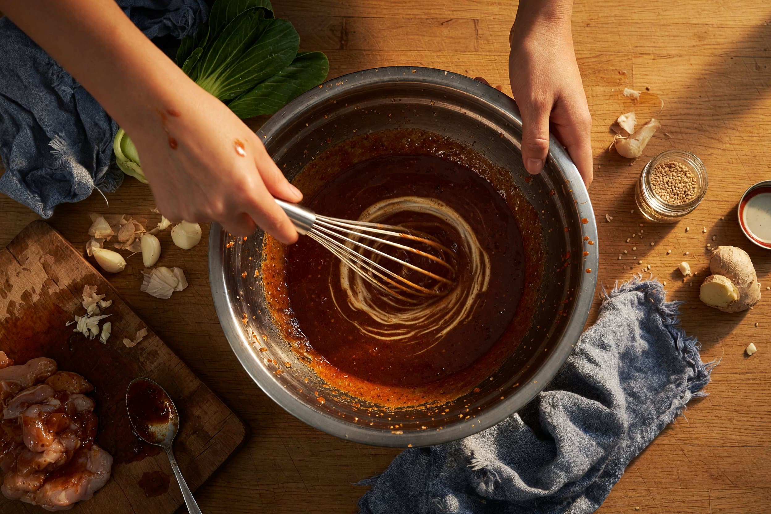 Whisking gochujang, soy sauce, honey, sesame oil, garlic, ginger, rice vinegar while preparing Korean Gochujang Chicken Thighs with Steamed Bok Choy