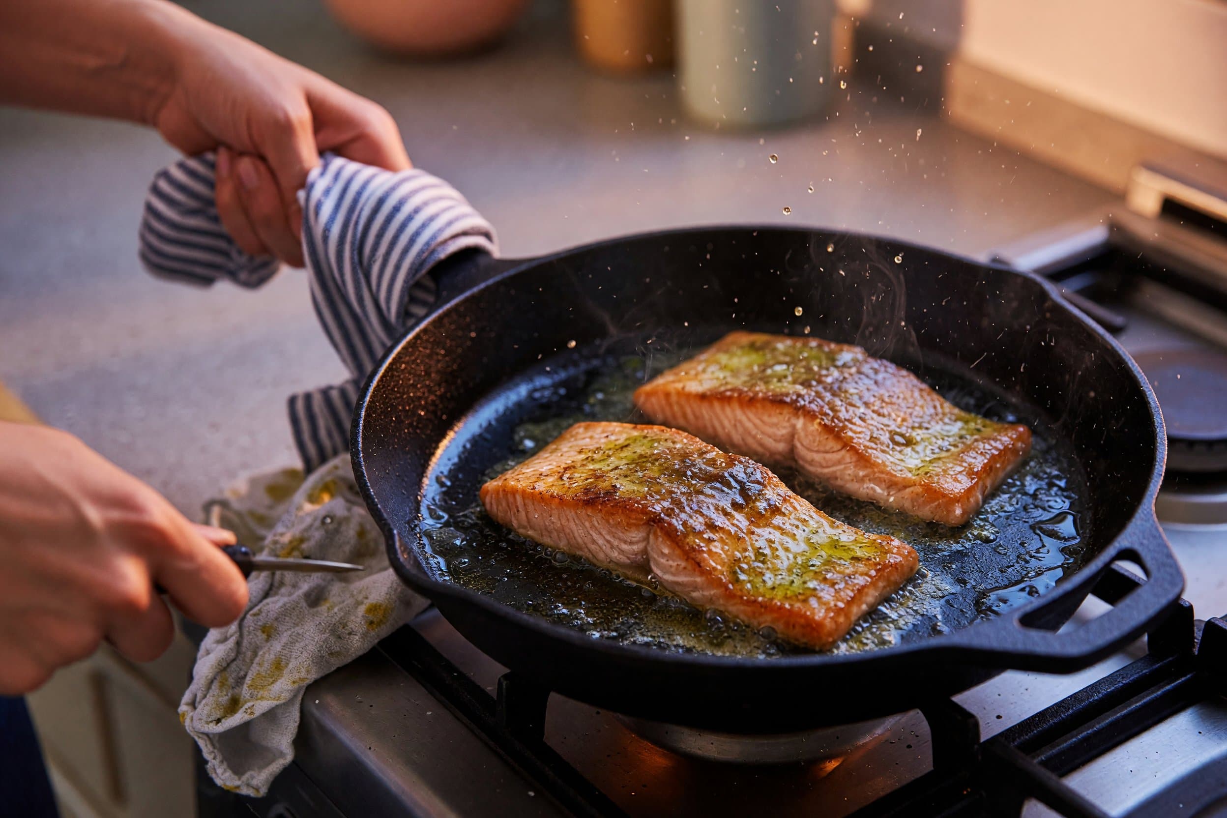 Searing salmon fillets while preparing Creamy Garlic Parmesan Salmon with Roasted Asparagus
