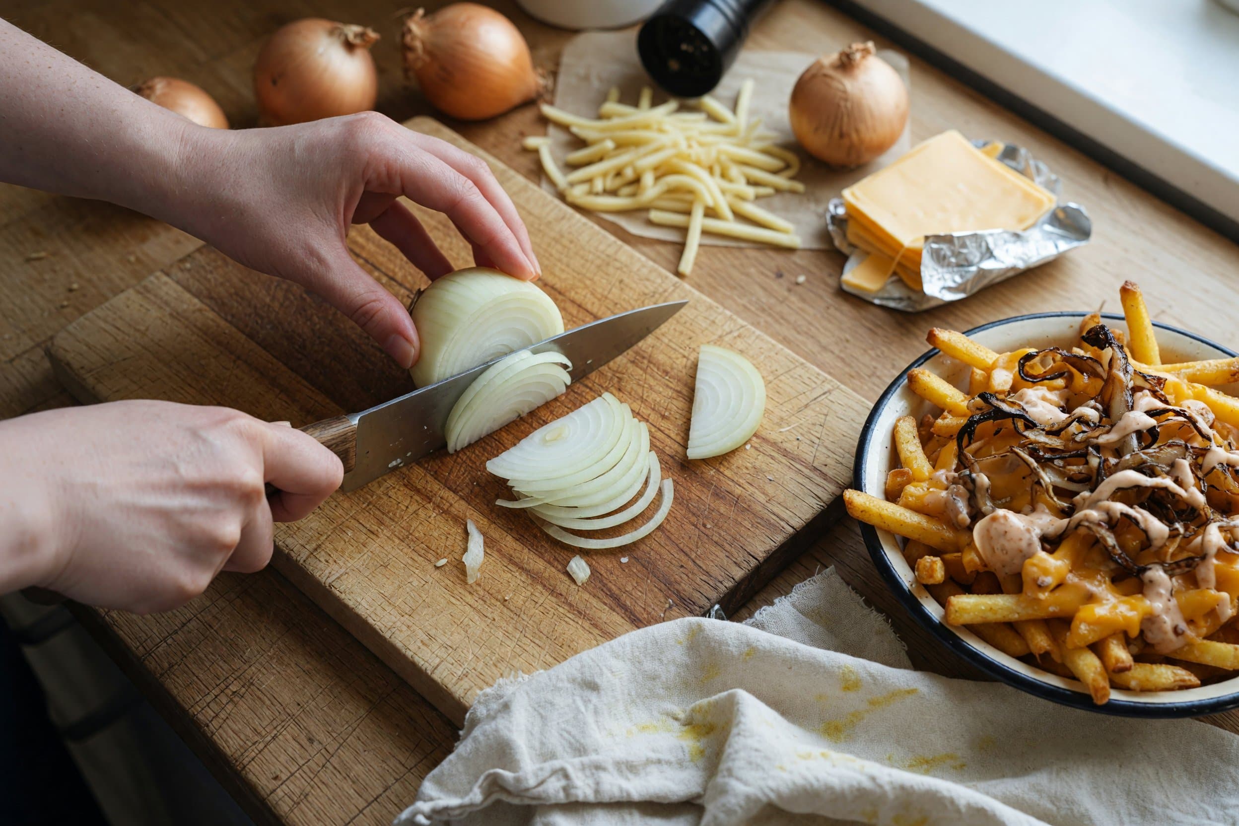 Slicing onion while preparing Animal Style Fries